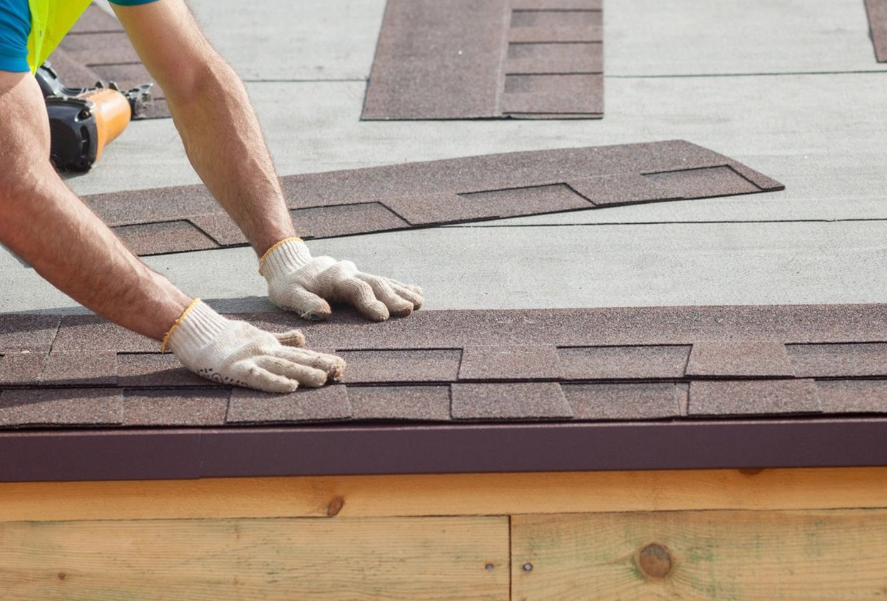 Roofer builder worker installing roof shingles